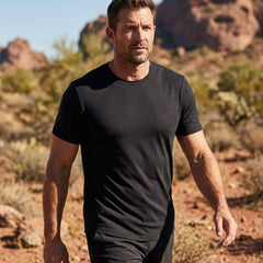 Man in a black t-shirt walking in a desert landscape